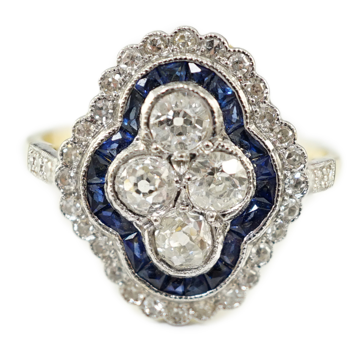 A modern 18ct gold, sapphire and diamond set quatrefoil shaped cluster ring